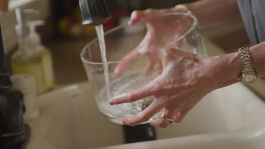 Women do the dishes in the kitchen during daylight