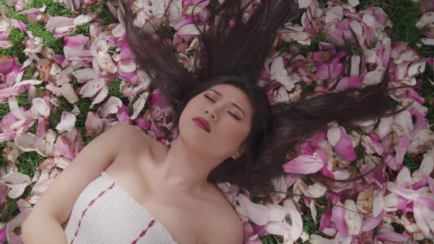 Asian women sleeping in the bunch of pink petals