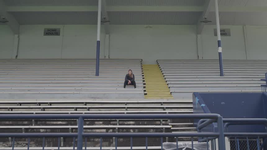 Boy sitting in the bleachers