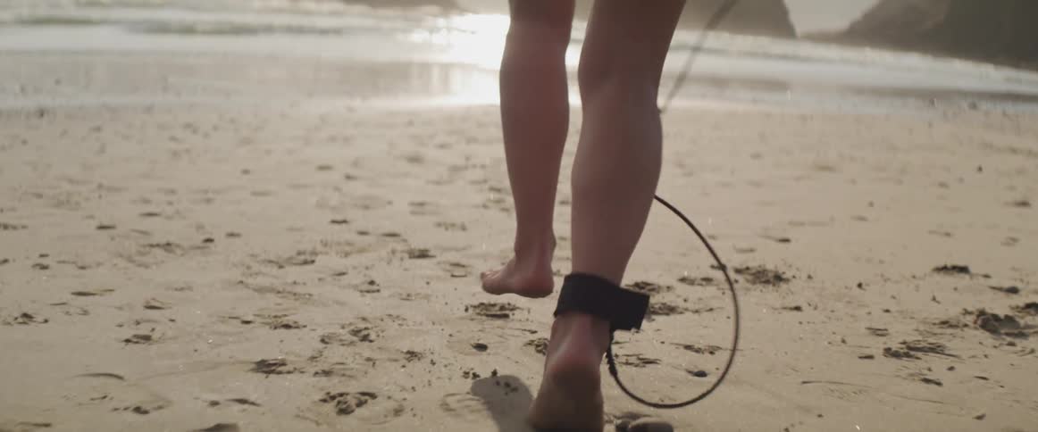 A woman is jogging on the beach