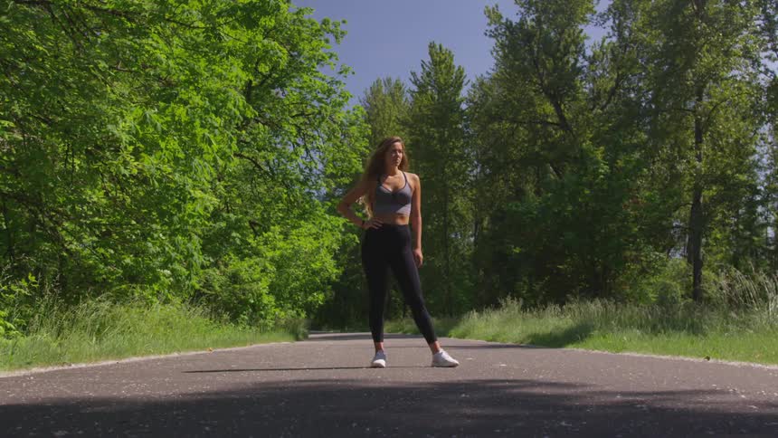 A young woman stands in the middle of a path