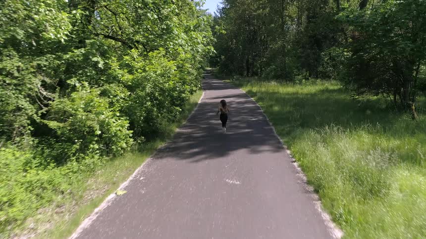 A white woman runs down a country road