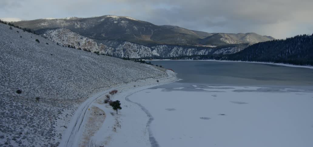 Snow covers a mountain lake on a winter day