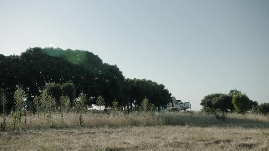 A small plane is parked in a barren field