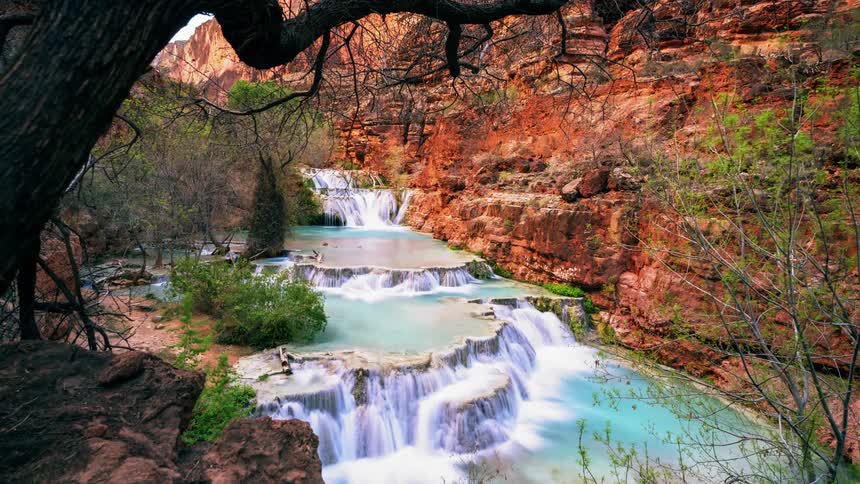 People climb down the rocks in the waterfall