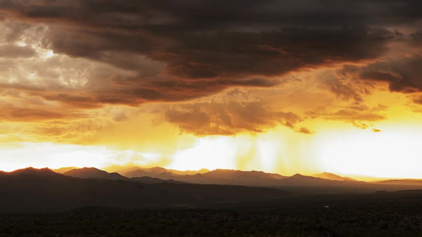 Storm forms over mountains at sunrise