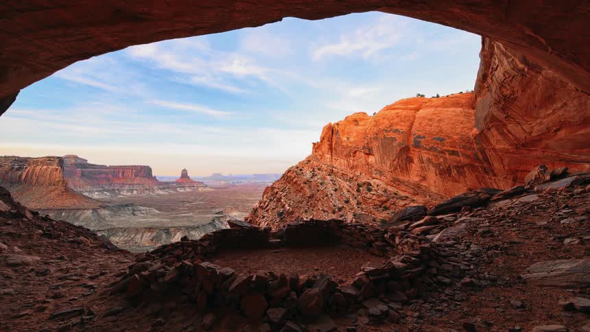 Outside the dark cave is a large valley of hills and mountains