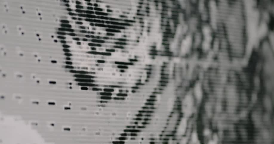 A pixelated image spins on a monitor