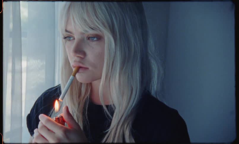 A teenager lights up a cigarette