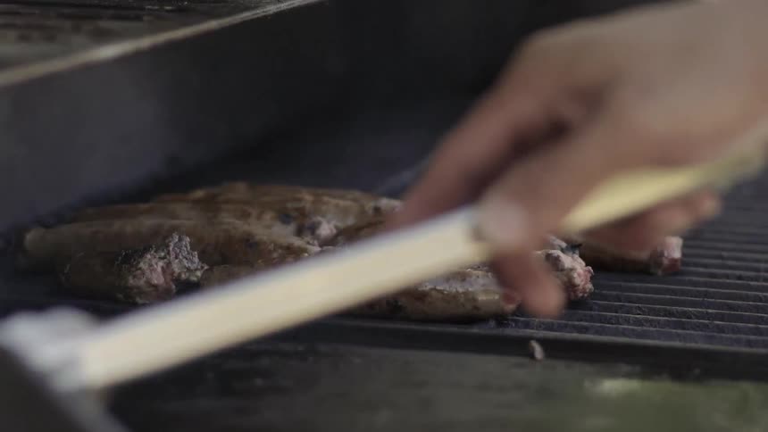 Meat Cooking on Outdoor Grill Over Open Flame in Rustic Barbecue Setting.