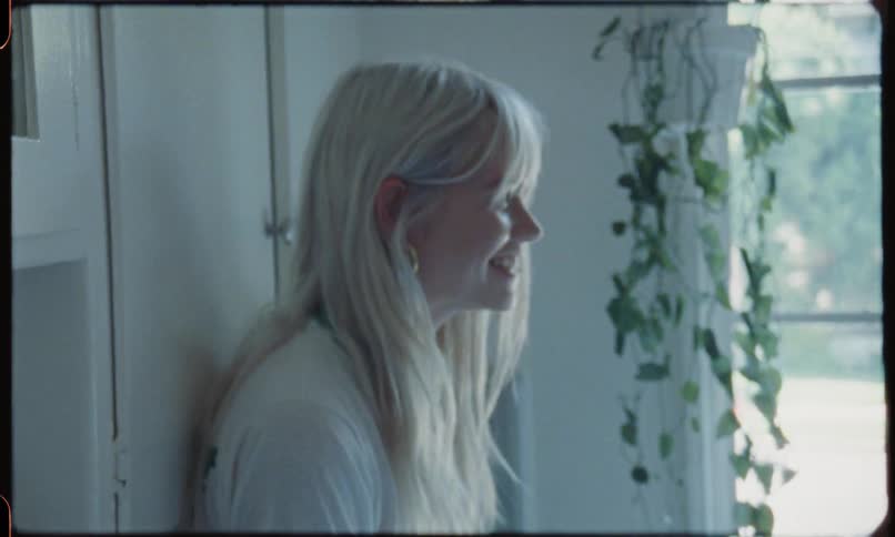 A blonde female preens and laughs in conversation