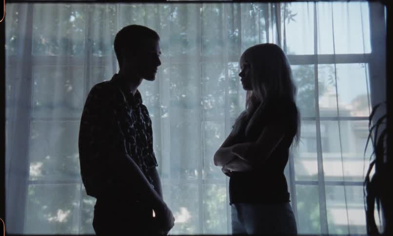 Young couple staring at each other in a dim lit room