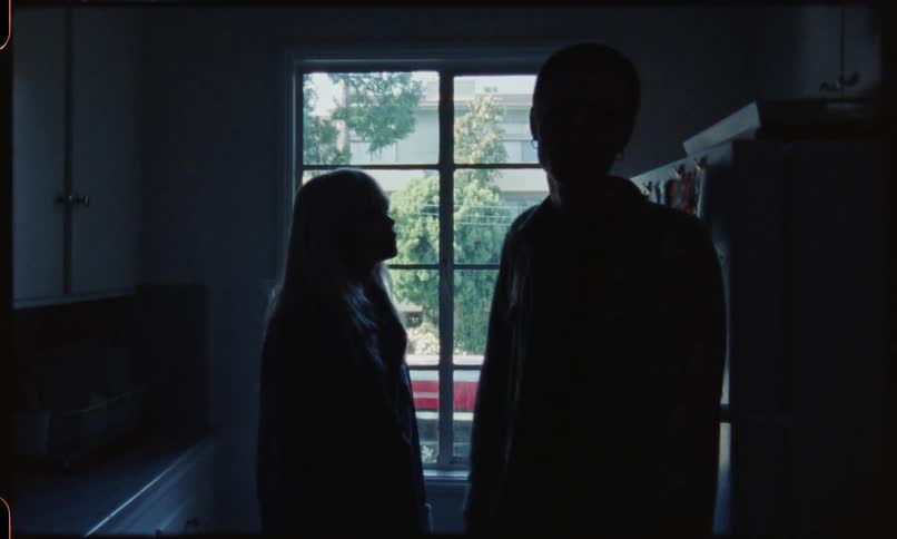 Blonde female arguing and pushing male onto refrigerator