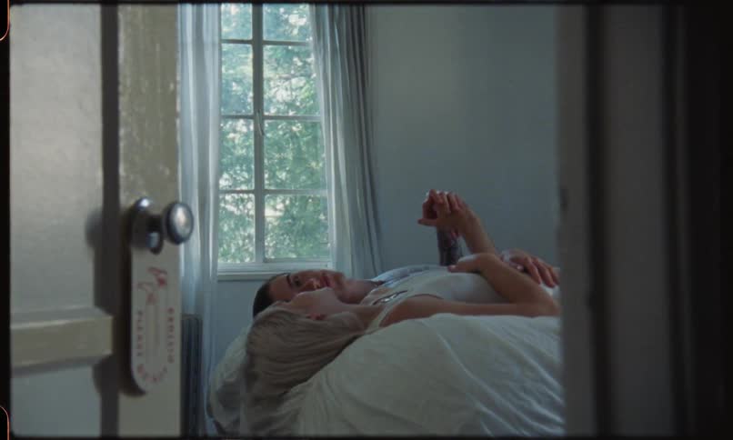 Man and woman lie down on the bed and talk to each other indoors during daylight
