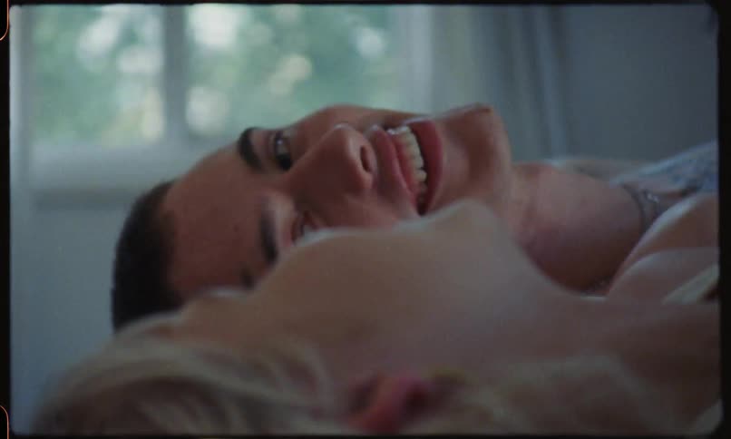Man and woman lie down and talk to each other indoors during daylight