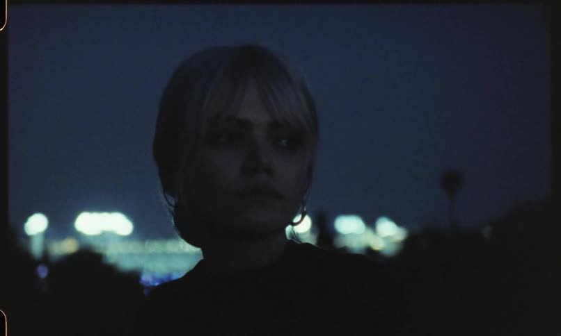 Woman standing outside a stadium at night