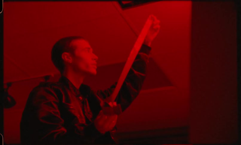 Photographer looking at film in darkroom