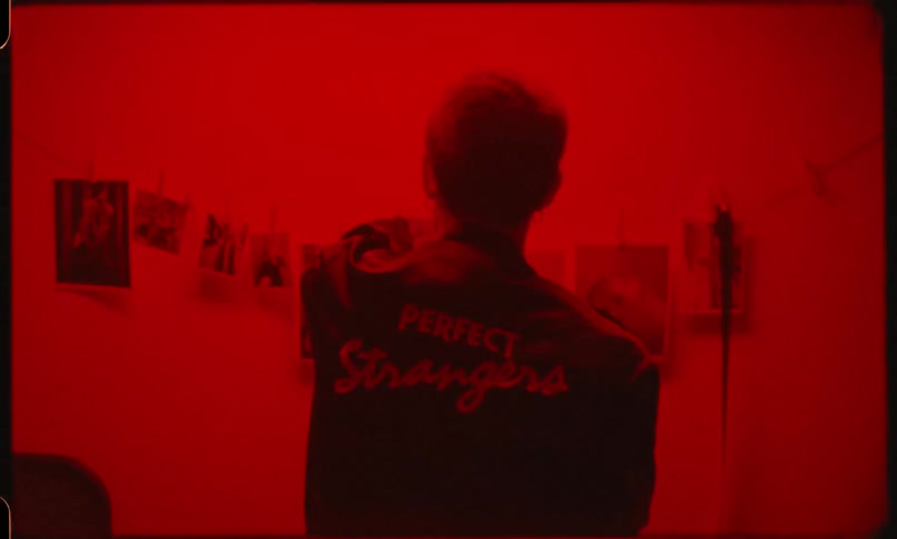 A man looks at photos in a dark room