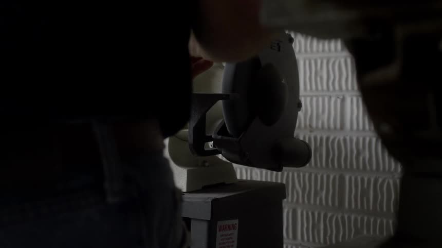 A man uses a grinding wheel as sparks fly