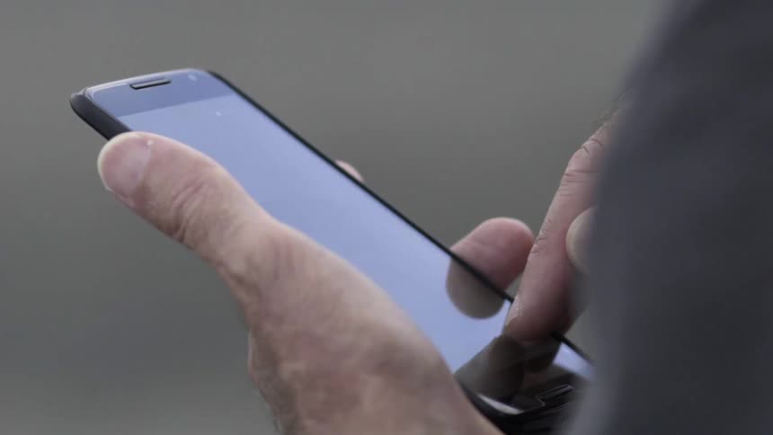 Hands Using Mobile Phone Outdoors in Natural Light During Casual Everyday Moment.