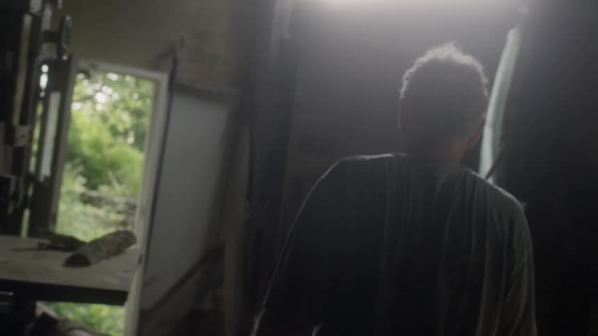 A man walks to the door of a workshop