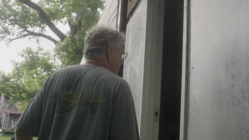 A man walks towards an old building and enters