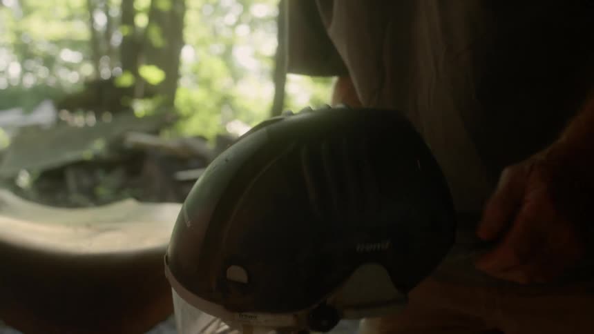 A man holds and inspects a welders helmet