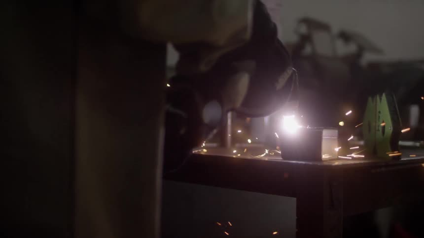 A person is in a workshop using tools