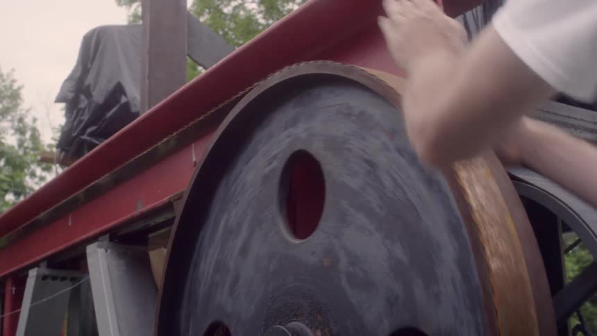 A man is turning a wheel on a machine