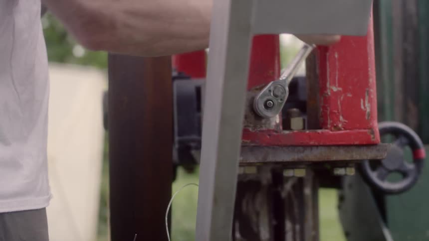 A man using a tool on a machine