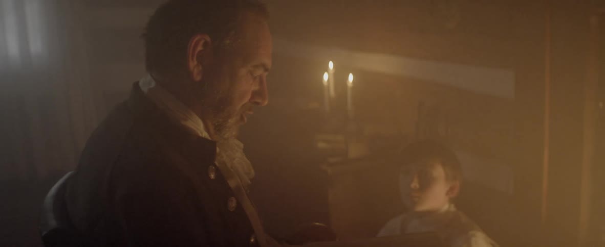 A man is talking to a child in a dark room