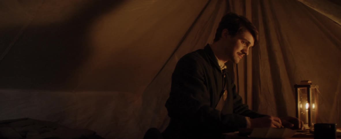 A man is in a tent writing