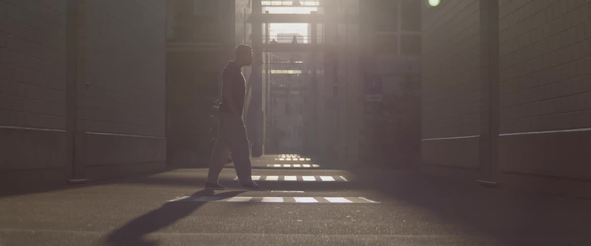 A man hip hop dances on a sidewalk outside