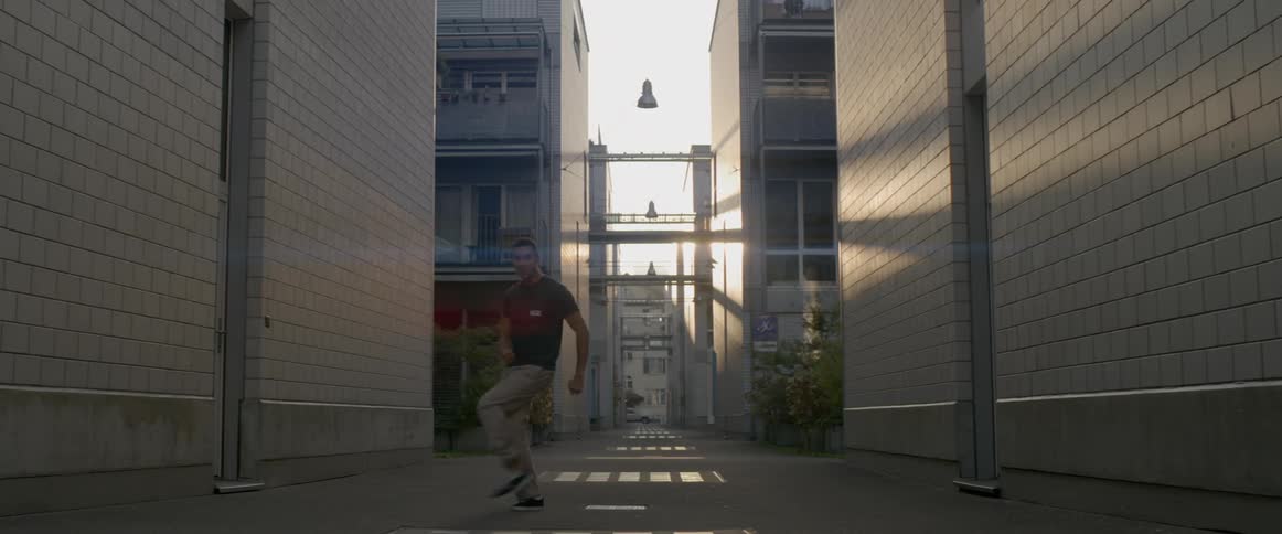A man dances in a street alley