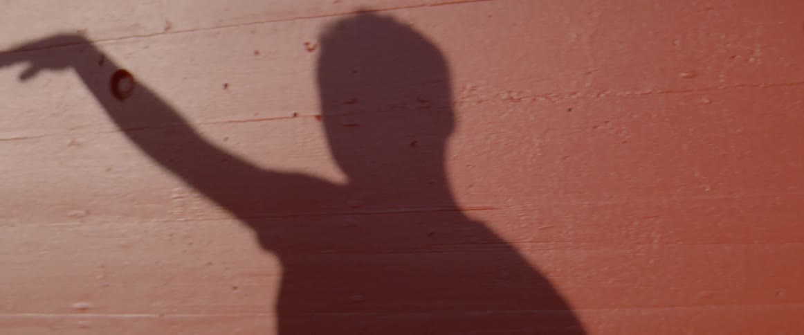 A dancing mans shadow is cast on a wall