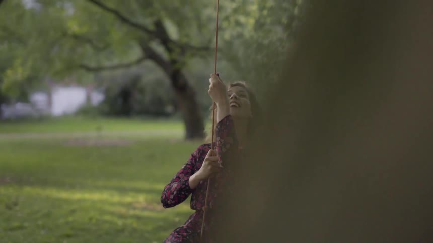 A woman is swinging on a tire