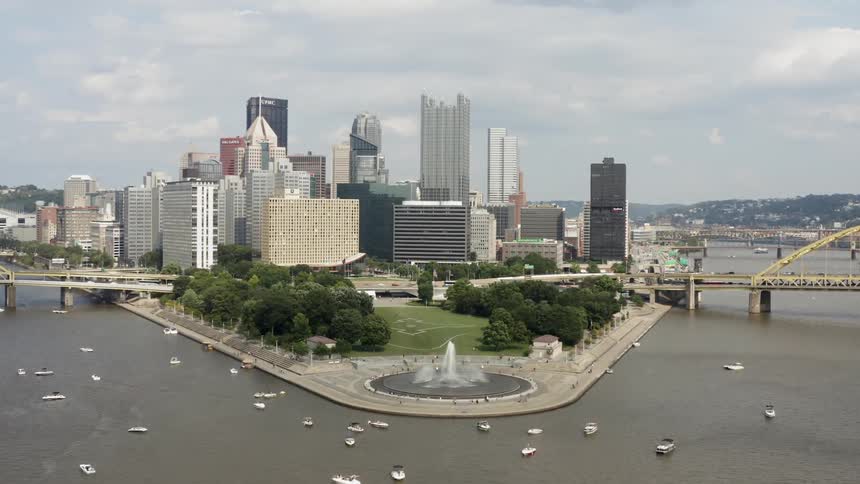Many boats sail around the water by the city
