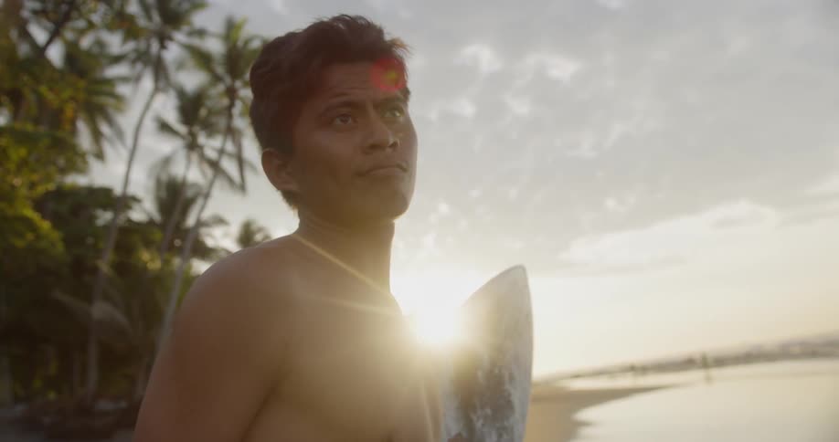A man is holding a surfboard outdoors