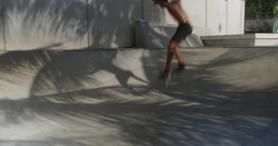 A man rides a skateboard and jumps a ledge