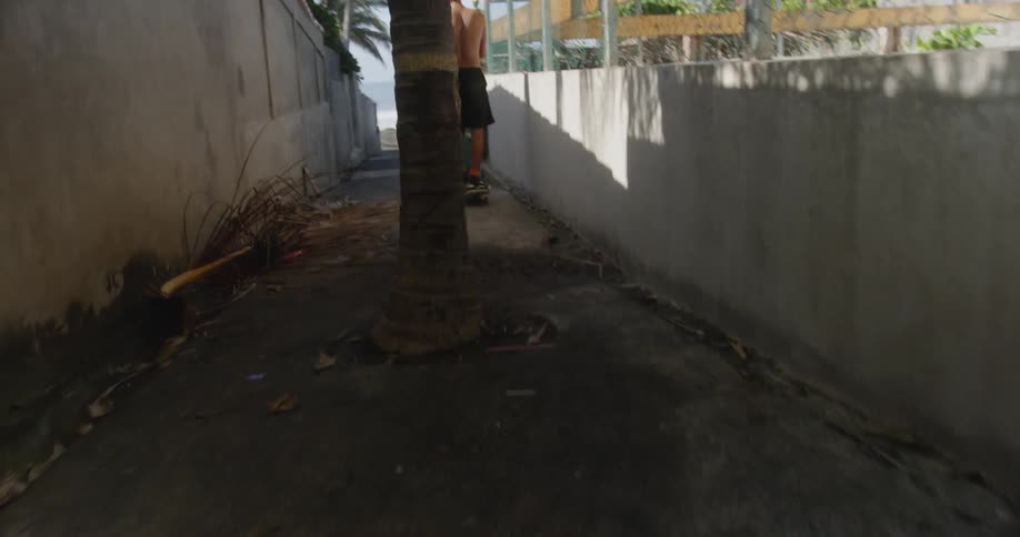 Man rides skateboard along narrow alley