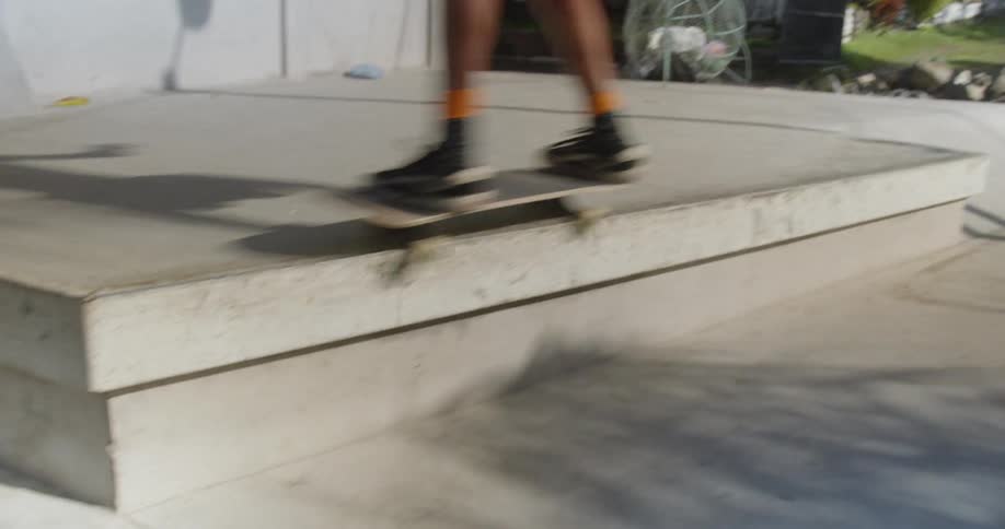 A skateboarder skates off a step at a skate park