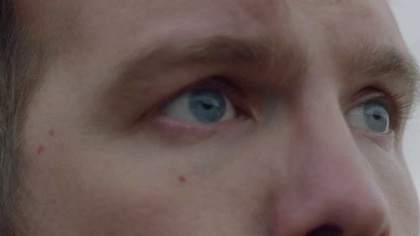 Closeup of a mans eyes as he turns his head and blinks