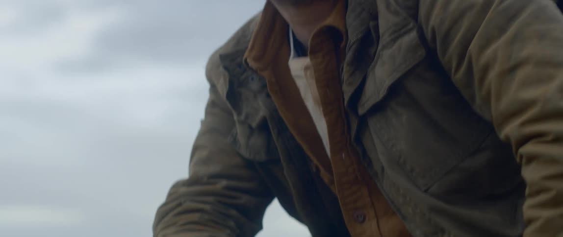 A man uses a walkie talkie outside of a tent