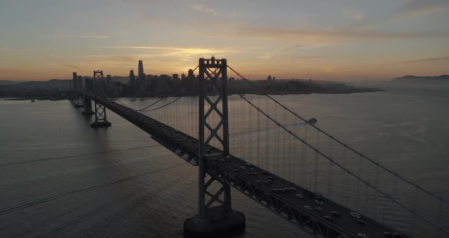 A suspension bridge over water with cars traveling on the bridge