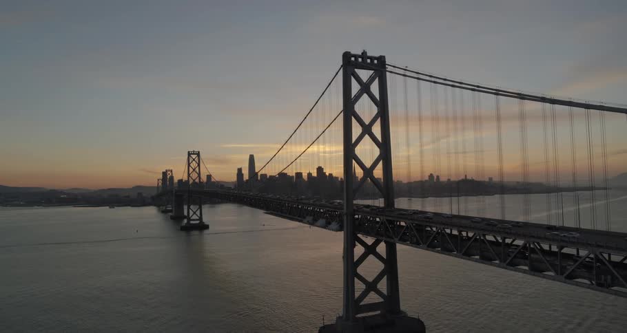 Cars travel a long bridge to and from a major city