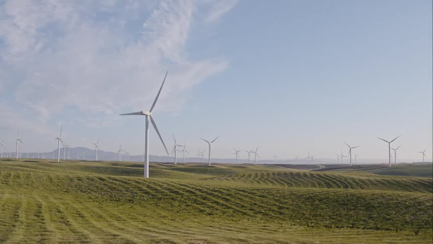 The windmills slowly turn on the hills