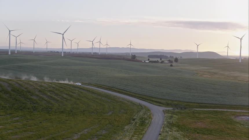 A car is driving in a rural grassland area