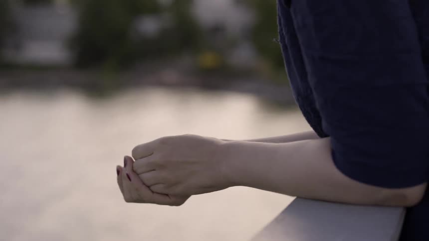Close up of woman rubbing her hands together in natural light.
