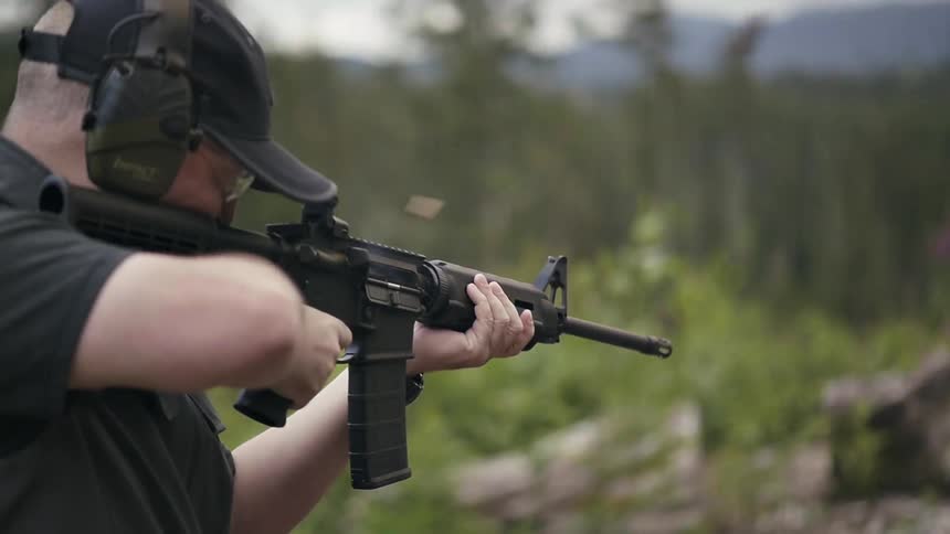 A man is firing a rifle