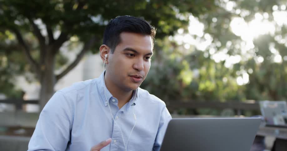 Man looks at a laptop as he talks